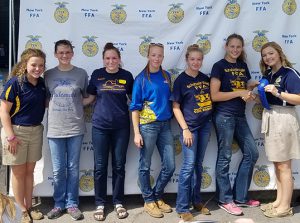 FFA member students standing in front of banner at Fair