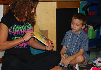 teacher reads to kindergarten boy