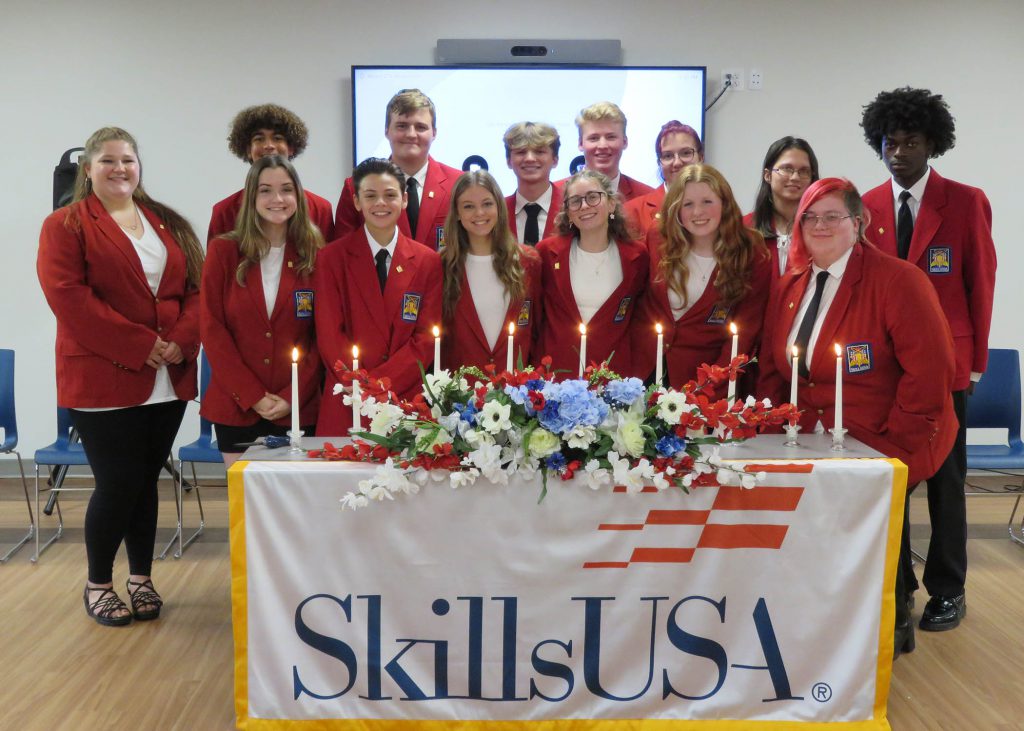 SkillsUSA students stand behind a table