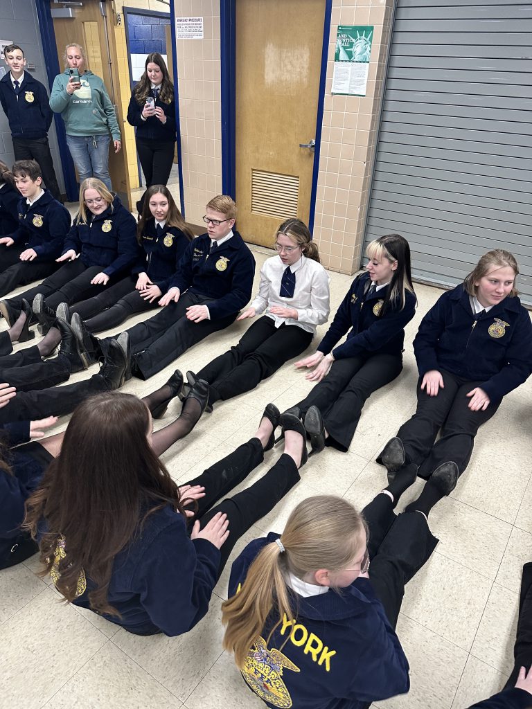 Students sit on the floor