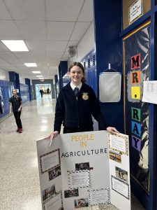 A student holds a poster board