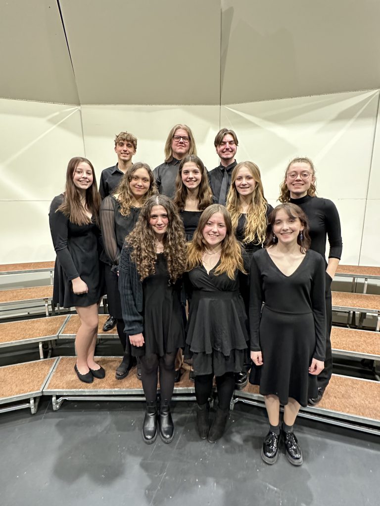 Eleven students stand on stage