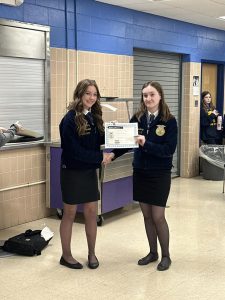 Two students hold a certificate