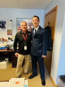 An airman stands next to a superintendent