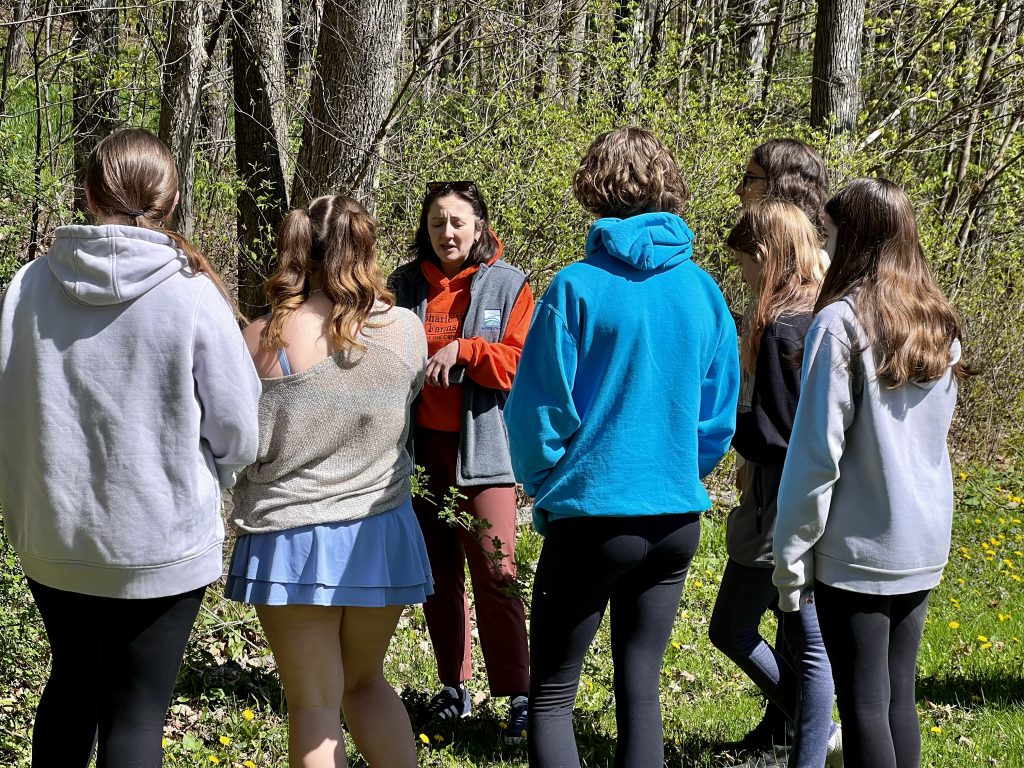 Students listen to an outdoor lecture