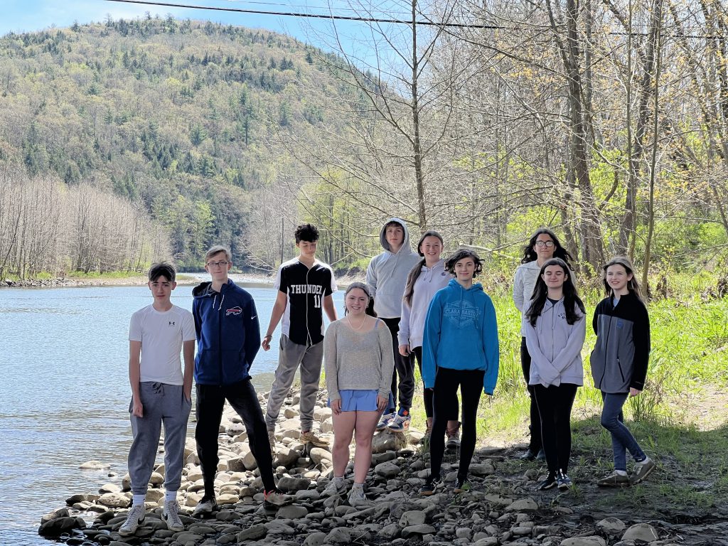 Students stand next to a lake