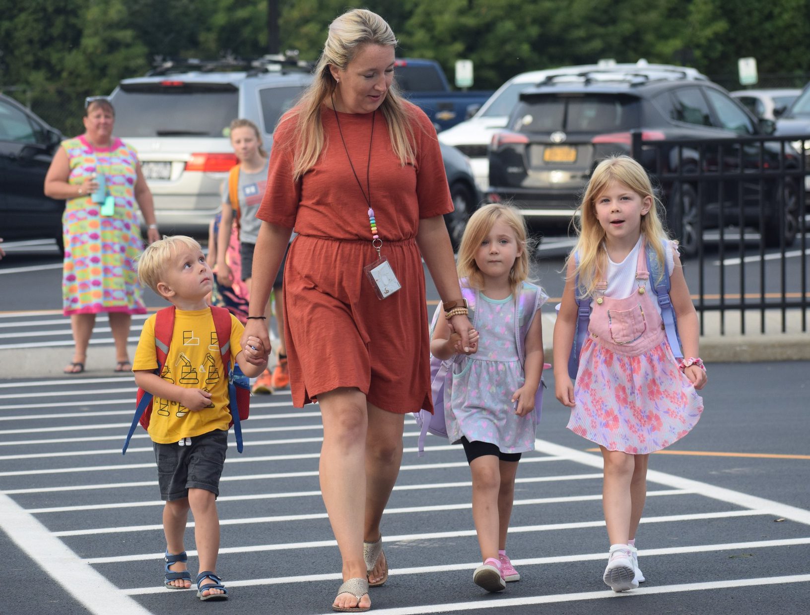 A teacher poses proudly with her junior high students dressed in concert clothing.
