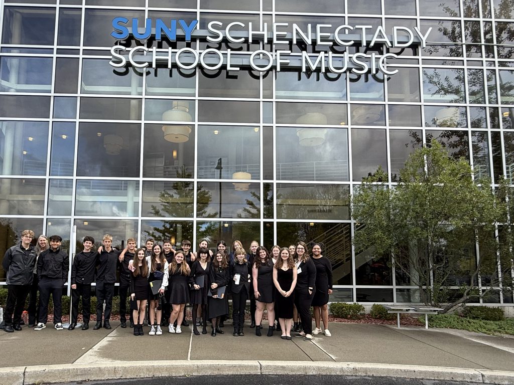 Students stand in front of a building