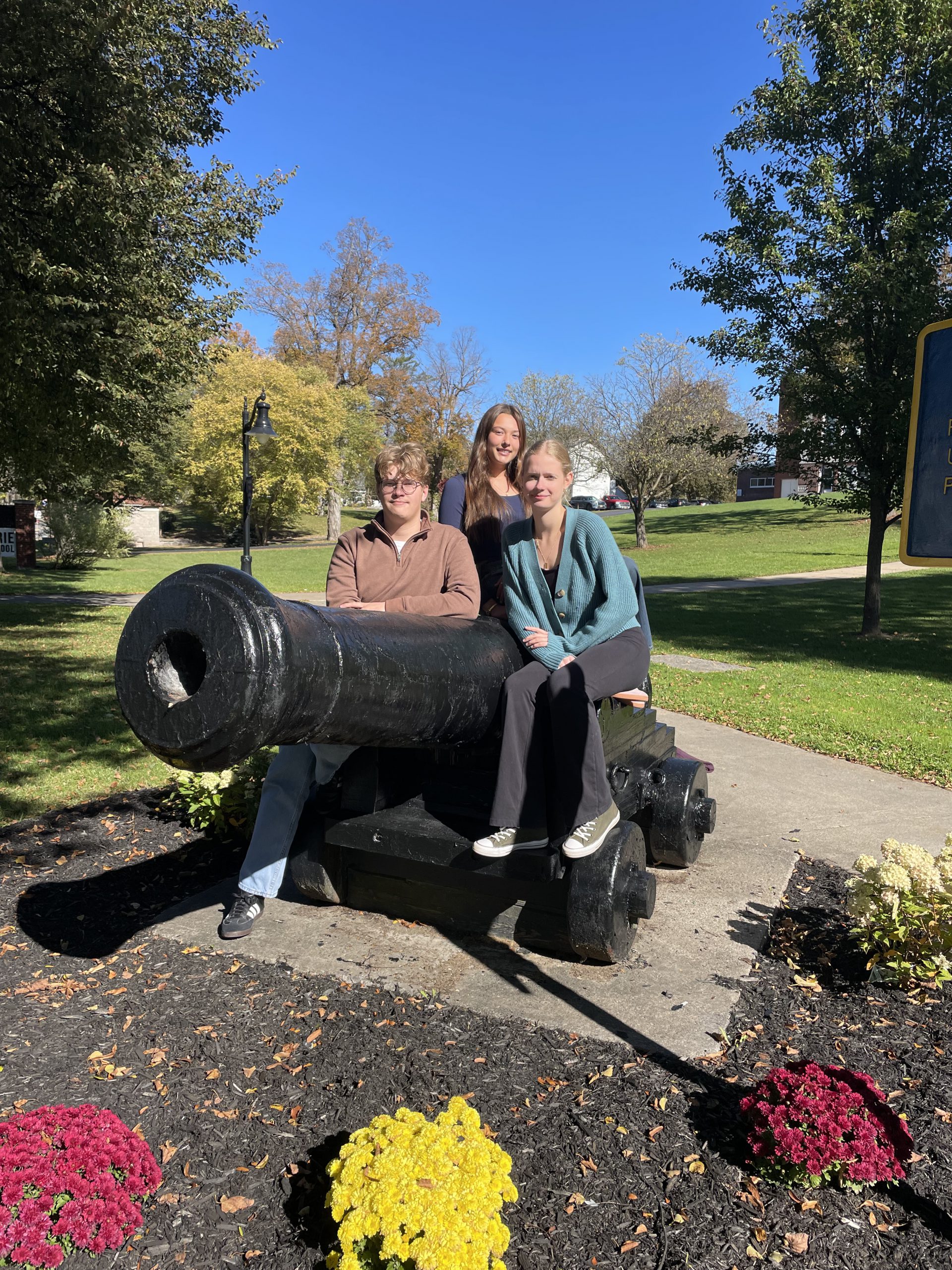Three students near a cannon