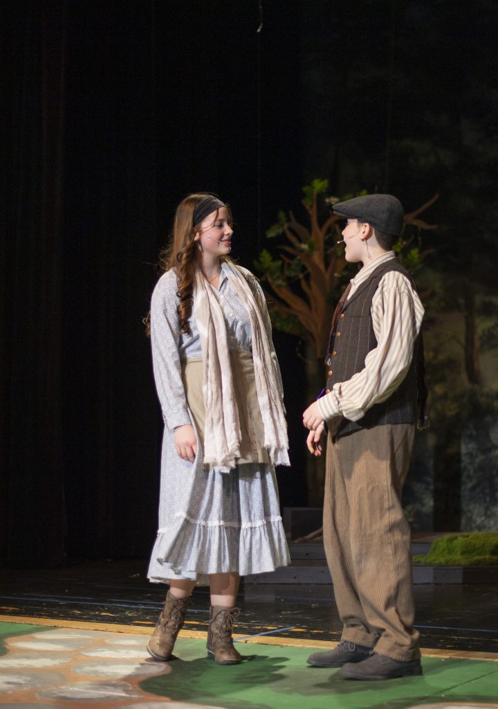 two students perform on stage