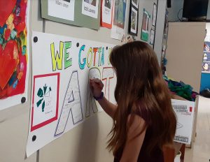 A student draws on a poster
