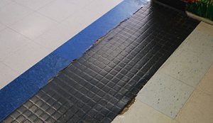 a floor with cracks and crumbing tiles in the high school