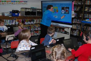 librarian using SmartBoard while students listen