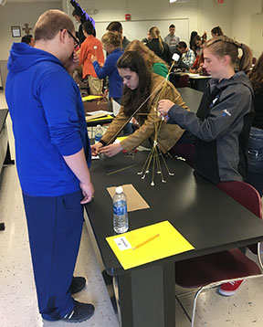 high school students work on a table experiment