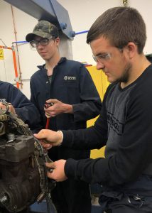 Two students work on a motor