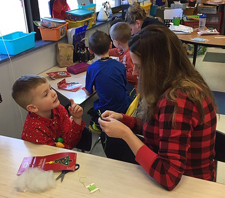 student and teacher work on crafts