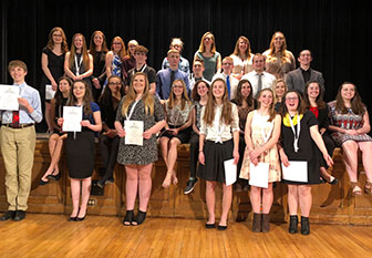 group of student stand with their awards
