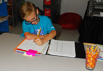 boy writing in his notebook