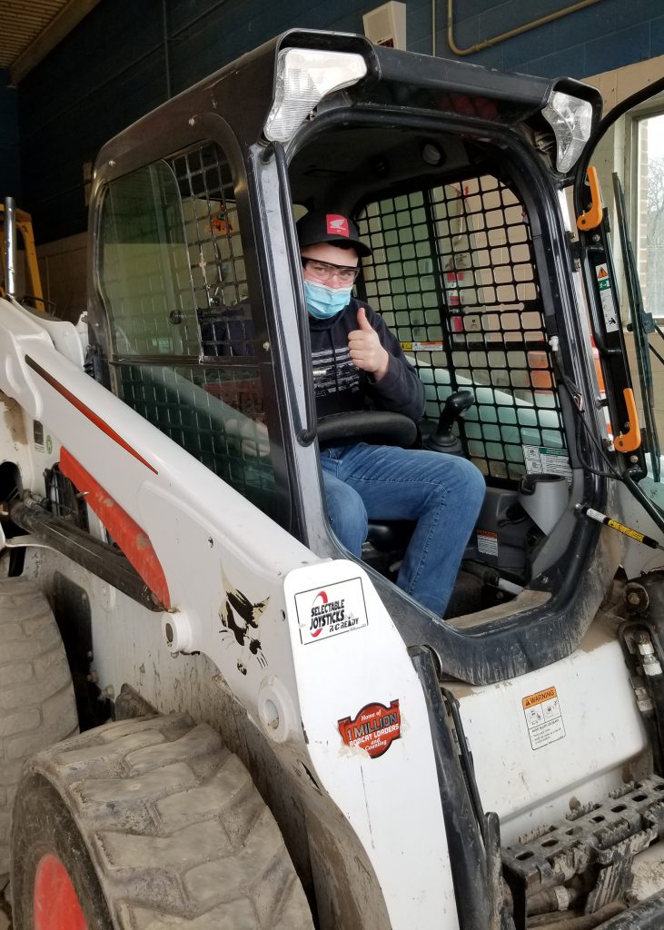 A student sits in a bobcat vehicle