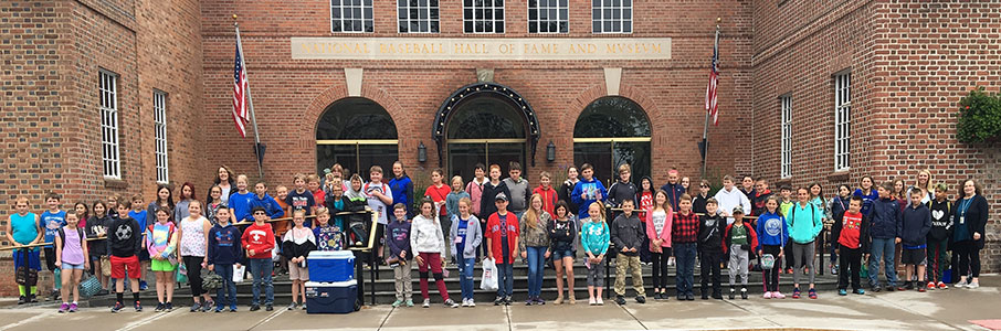 large group of students and staff standing in front of the Baseball Hall of Fame