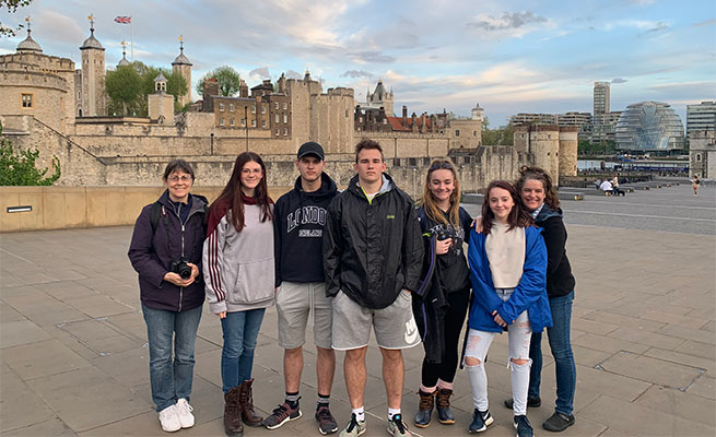 6 students, 1 adult pose in United Kingdom