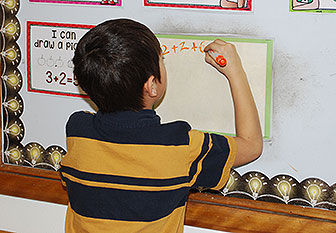boy writes on a wall board