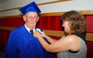 woman pin a flower on a veteran graduate