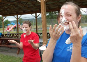 principal and teacher with pie on their faces and hands