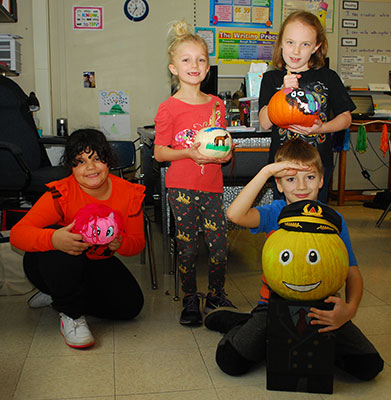 3 girls and 1 boy holding pumpkins